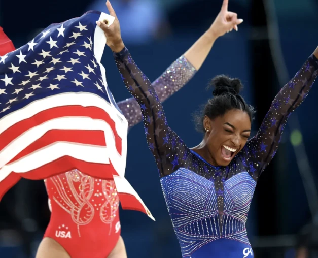 Simone Biles celebrarting with an American Flag.